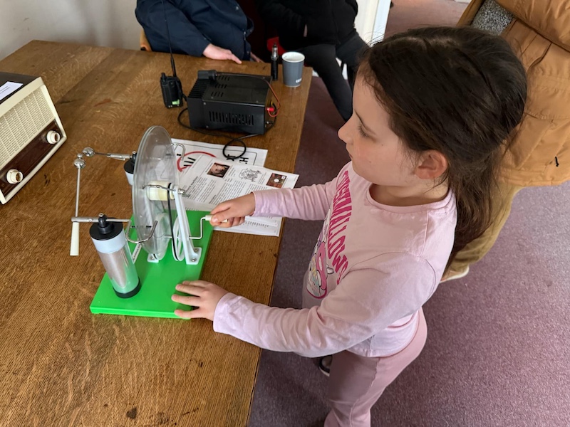 Young girl using a Windhurst Machine to generate static electricity.